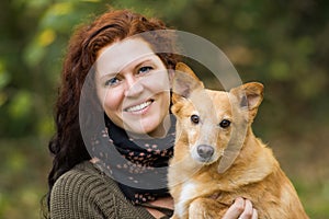 Young woman holds dog in her arms