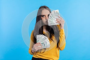 The young woman holds a fan of paper banknotes with a face value of one hundred zlotys