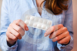 Young woman holds pills in hands. Taking vitamins, supplements, antibiotic, antidepressant, painkiller medication.