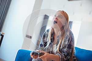 Young woman at home in the living room shocked by the game