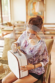 Young woman at home packing bag