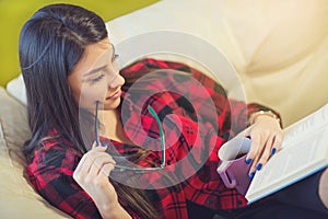 Young woman at home sitting on sofa relaxing in her living room