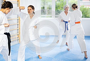 Young woman honing punching techniques during kumite at karate training