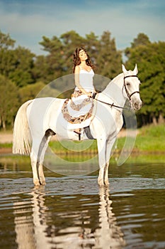 Young woman on a horse. Horseback rider, woman riding horse on b