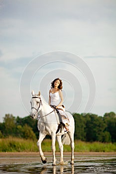 Young woman on a horse. Horseback rider, woman riding horse on b