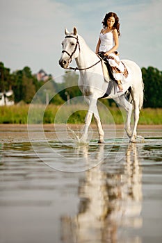 Young woman on a horse. Horseback rider, woman riding horse on b photo