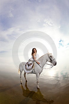 Young woman on a horse. Horseback rider, woman riding horse on b photo