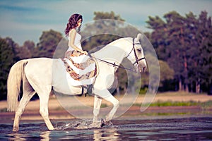 Young woman on a horse. Horseback rider, woman riding horse on b photo