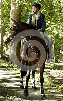 Young woman horse riding in the forest