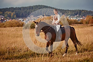 Young woman horseriding in sunset on the fields. Close up