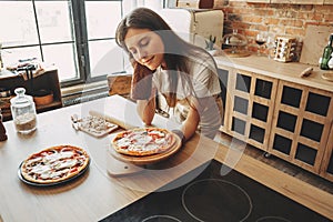 Young woman housewife baking homemade pizza