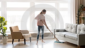 Young woman housewife clean floor in modern living room