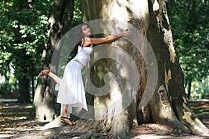 Young woman hugging ancient tree