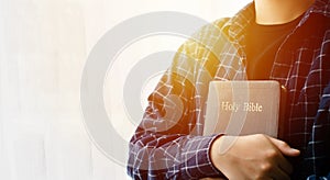 Young woman hugging bible and praying  god faith forgiveness