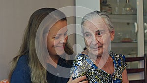 Young woman hugging her ninety year old grandmother.