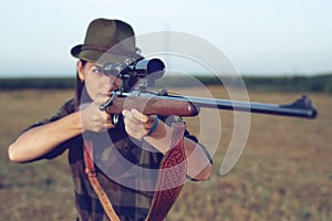 Young woman hunting. woman holding gun.