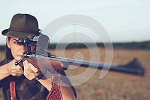 Young woman hunting. woman holding gun.