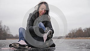 Young woman ice skating on a frozen lake on a freezing winter day. People, winter sport and leisure concept.