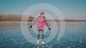 Young woman ice skating on a frozen lake on a freezing winter day. People, winter sport and leisure concept.