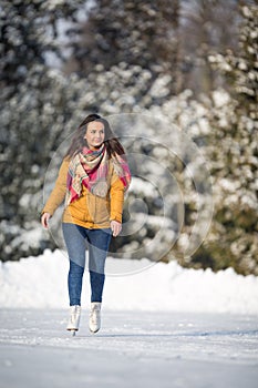 Young woman ice skating outdoors on a pond