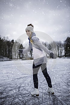 Young woman ice skating outdoors on a pond