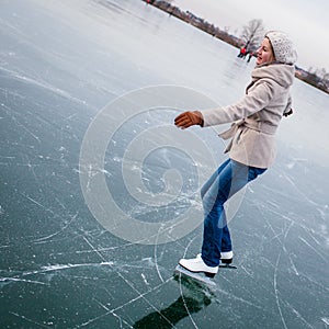 Young woman ice skating outdoors on a pond