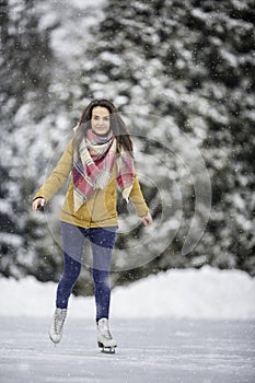 Young woman ice skating outdoors on a pond