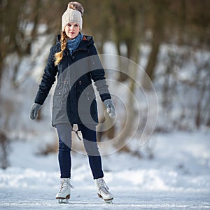 Young woman ice skating outdoors on a pond