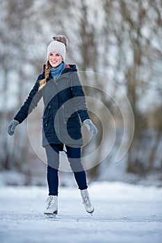 Young woman ice skating outdoors on a pond