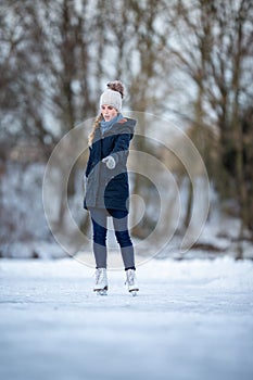 Young woman ice skating outdoors on a pond