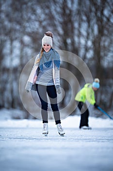 Young woman ice skating outdoors on a pond