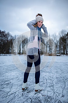 Young woman ice skating outdoors on a pond