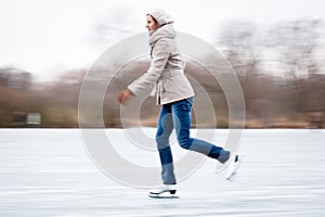 Young woman ice skating outdoors on a pond