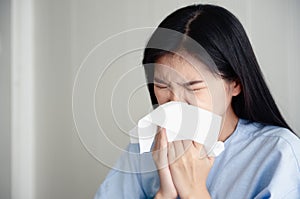 A young woman is ill and snot. flu season. Achoo