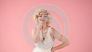 A young woman in the image of Marilyn Monroe points her index finger at you. Woman with bright makeup and in white dress