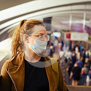 A young woman with an incorrectly put on medical mask in transport