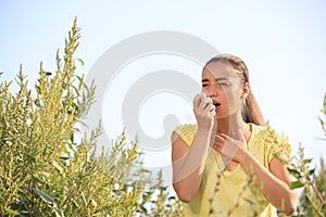 Young woman with inhaler suffering from ragweed allergy