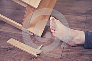 Young woman injured her foot due to falling from a broken chair