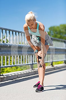 Young woman with injured knee or leg outdoors