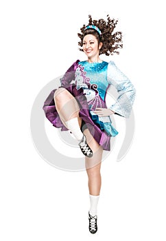 Young woman in irish dance dress dancing isolated