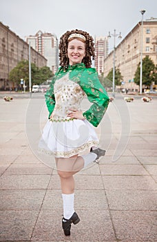 Young woman in irish dance dress and wig dancing