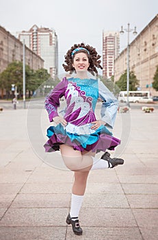 Young woman in irish dance dress and wig dancing