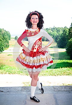 Young woman in irish dance dress and wig posing outdoor