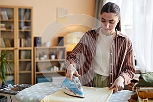 Young Woman Ironing Clothes on Ironing Board