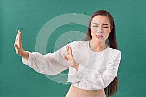 Young woman isolated on turquoise background being shocked due to an imminent danger