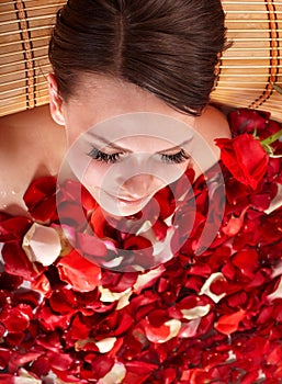 Young woman in jacuzzi with rose petal.