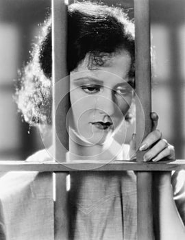 Young woman in a jail, looking sad photo