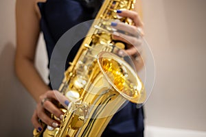 Young woman jazz musician playing the saxophone, closeup image