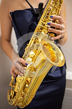 Young woman jazz musician playing the saxophone, closeup image