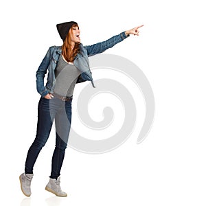 Young Woman In Jeans Jacket And Cap Is Standing, Pointing And Laughing
